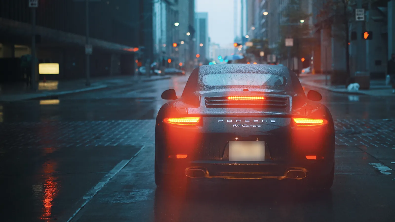 Voiture de sport Porsche 911 dans une rue sous la pluie