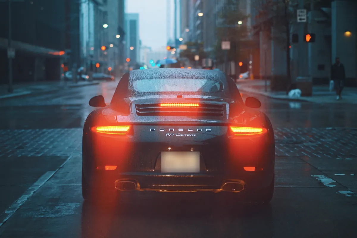 Porsche 911 sports car on a rainy city street